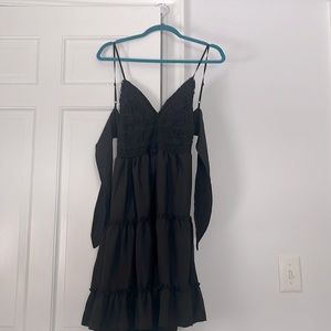 A black dress that ties in the back has a pattern on the top part.
